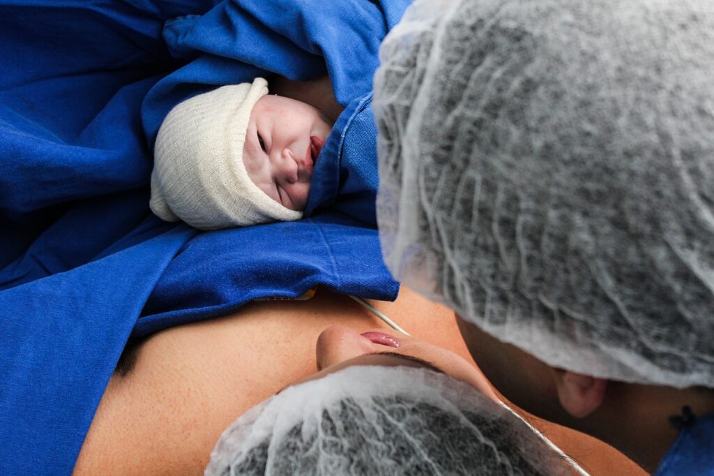 Newborn baby meeting mother and father immediately after c-section birth 
